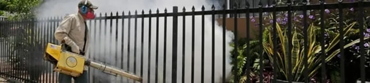 Mosquito control technician fogging a yard perimeter for mosquito reduction in Tuscaloosa, AL